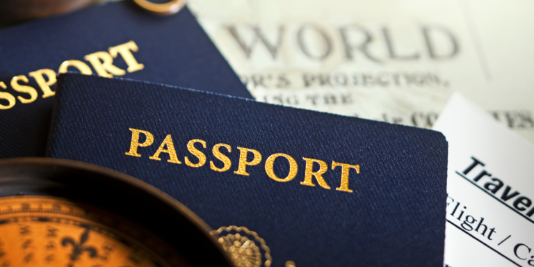 Flat-lay of blue passports, a travel itinerary, a compass, and a world map background, used in the blog Dubai Tourist Visa Requirements 2025 Don’t Fly Without Reading This Guide