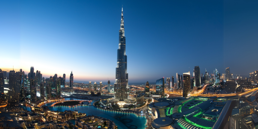 Evening skyline of Dubai featuring the iconic Burj Khalifa, with city lights reflecting modern architecture, used as a banner for a blog on Tourist Attractions in Dubai with a complete guide