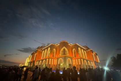 Crowds enjoying illuminated grand building at night during a trip to Dubai, showcasing the city’s vibrant cultural events and attractions.