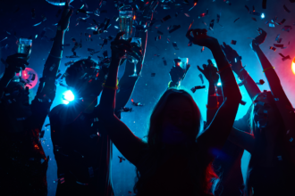 Group of friends partying with drinks and confetti at a vibrant nightclub, representing where to party in Dubai for unforgettable nightlife experiences.
