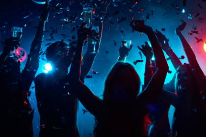 Group of friends partying with drinks and confetti at a vibrant nightclub, representing where to party in Dubai for unforgettable nightlife experiences.