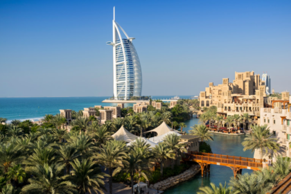 Iconic view of Burj Al Arab and traditional souk area in Dubai with lush palm trees, perfect for Dubai from India travel guides.