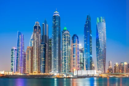 Colorfully illuminated skyscrapers of the Dubai Marina skyline at dusk, viewed across the waterfront, representing the vibrant atmosphere and modern cityscape where top Dubai festivals take place throughout the year.