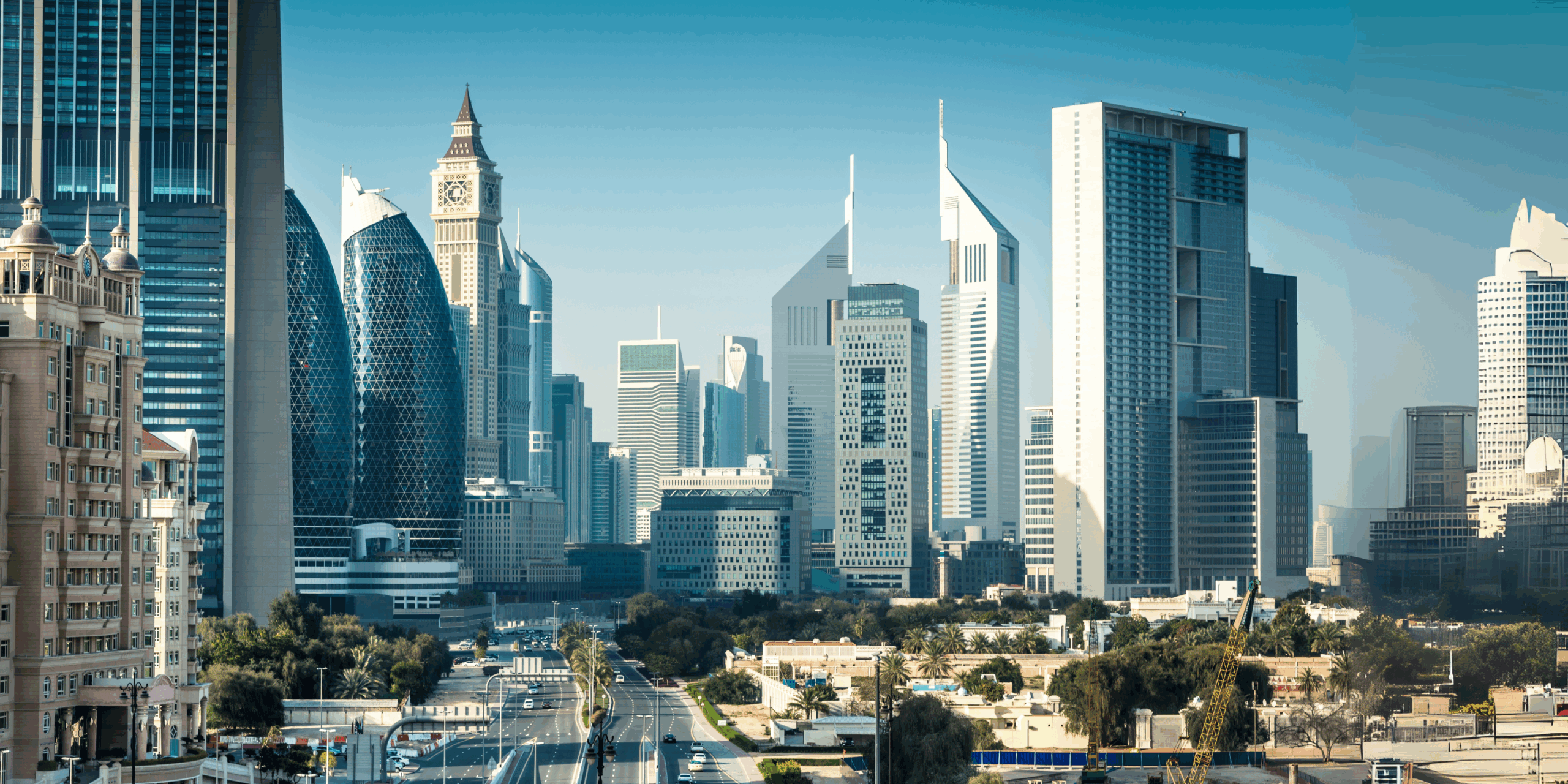 Daytime view of Dubai’s central business district featuring modern skyscrapers, including Emirates Towers and nearby high-rise architecture, with minimal traffic and clear skies—ideal conditions for off-season travel in Dubai.